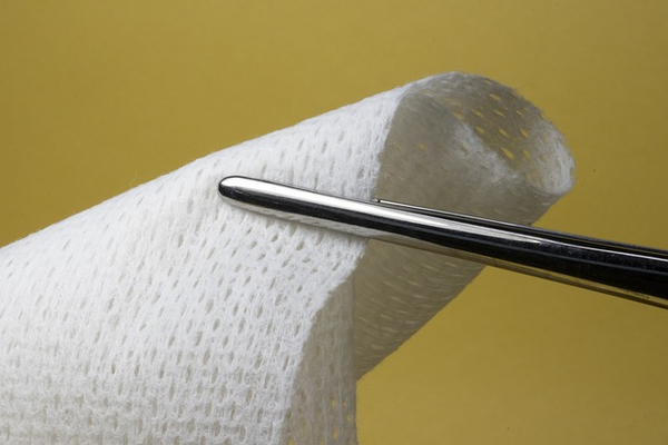 Medical tweezers holding gauze.