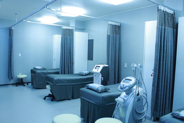 Hospital beds in a blue room.